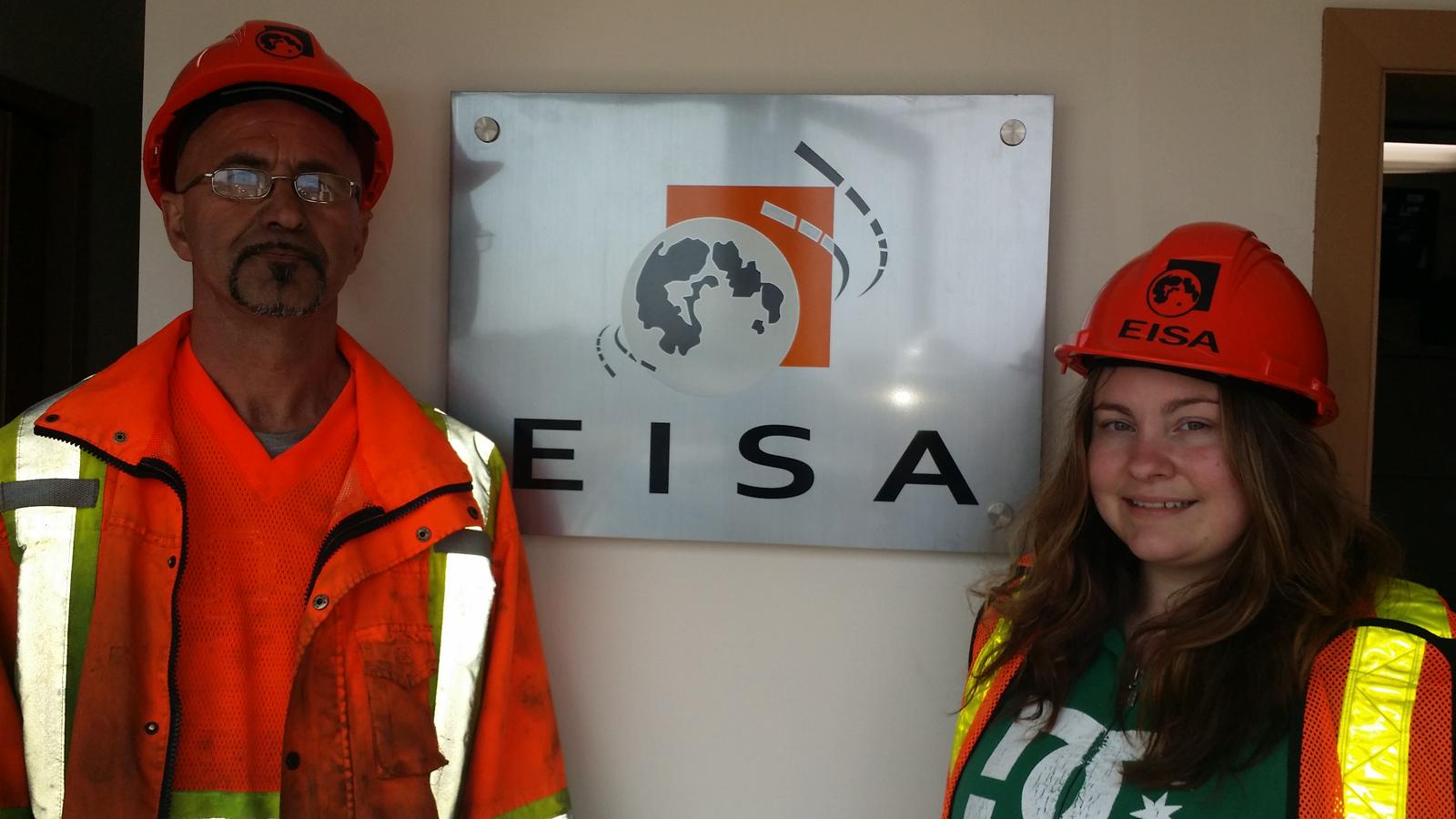 Two Eisa Trading Inc. team members beside the EISA sign